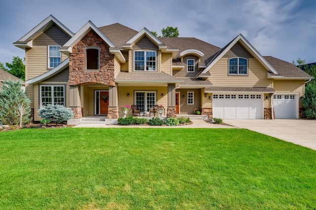 craftsman house featuring covered porch, a garage, and a front yard