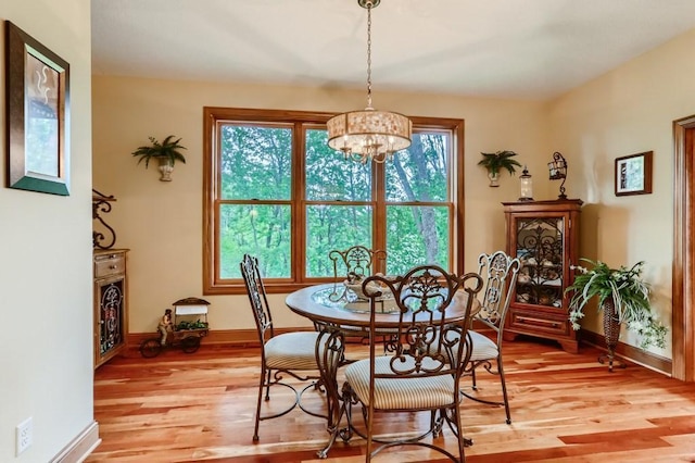 dining room with light wood-type flooring and a notable chandelier