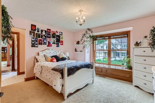 bedroom featuring light carpet, a textured ceiling, and an inviting chandelier