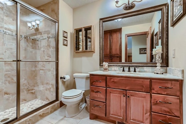 bathroom with vanity, a shower with door, tile patterned floors, toilet, and a textured ceiling