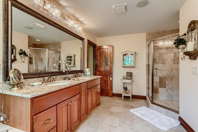 bathroom with vanity, a textured ceiling, and walk in shower