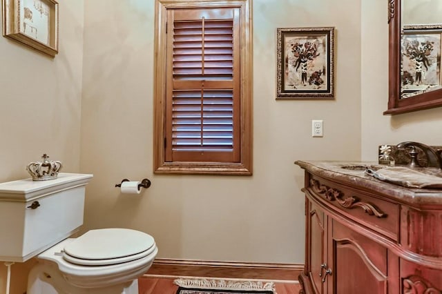 bathroom with hardwood / wood-style flooring, vanity, and toilet