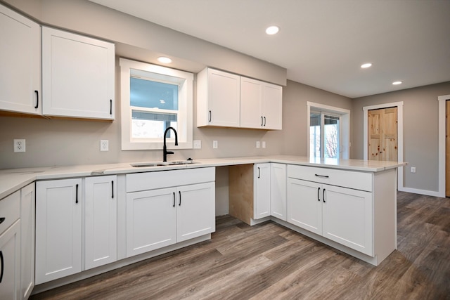 kitchen with hardwood / wood-style flooring, white cabinetry, and sink