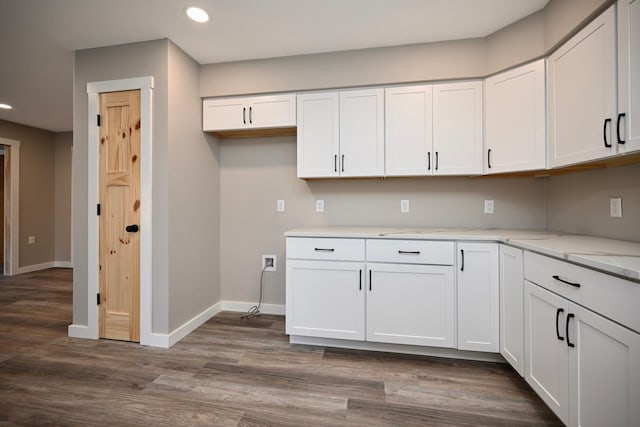 kitchen featuring light stone counters, white cabinets, and dark wood-type flooring