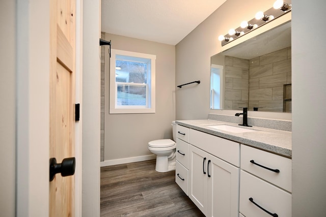 bathroom with vanity, hardwood / wood-style flooring, and toilet