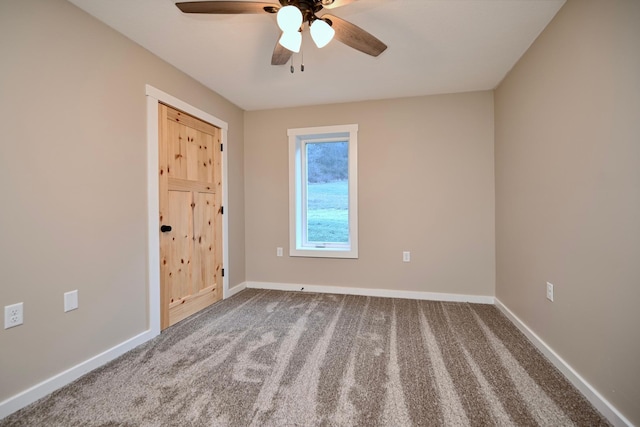 carpeted spare room with ceiling fan