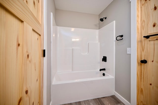 bathroom with bathing tub / shower combination and hardwood / wood-style floors