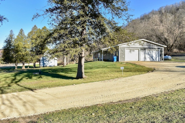 view of yard with a garage and an outbuilding