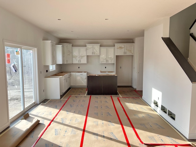 kitchen featuring a center island, white cabinetry, and plenty of natural light