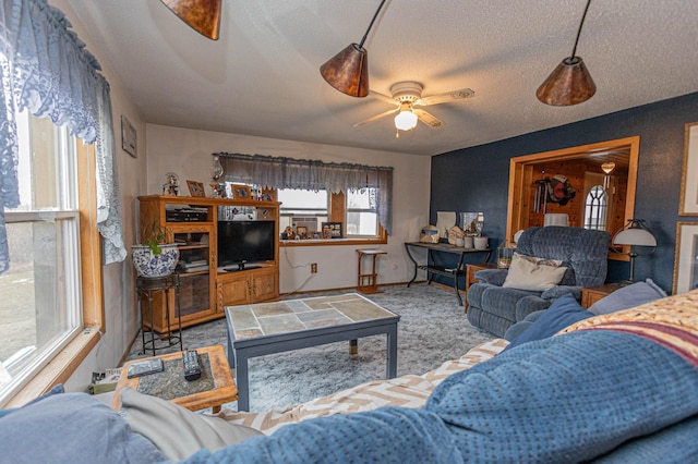 carpeted living room featuring a textured ceiling and ceiling fan