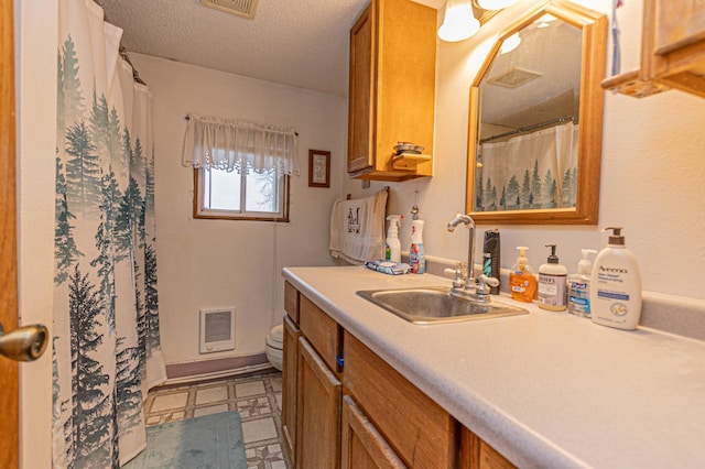 bathroom with walk in shower, vanity, a textured ceiling, and toilet