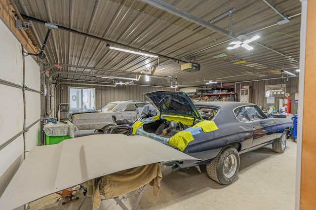 garage featuring wooden walls and a garage door opener