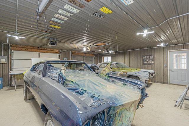 garage with a garage door opener and wooden walls