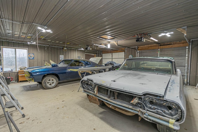 garage featuring a garage door opener and wood walls