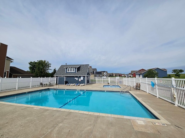 view of swimming pool featuring a patio area and an outbuilding