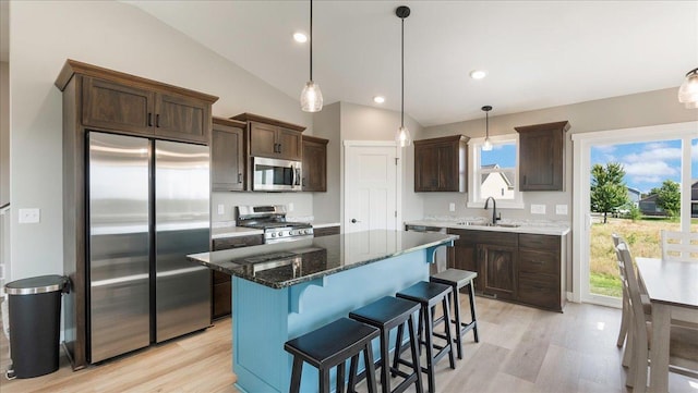 kitchen with sink, stainless steel appliances, lofted ceiling, and light hardwood / wood-style floors