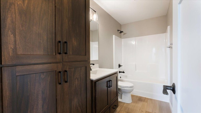 full bathroom with hardwood / wood-style floors, vanity, toilet, and tub / shower combination