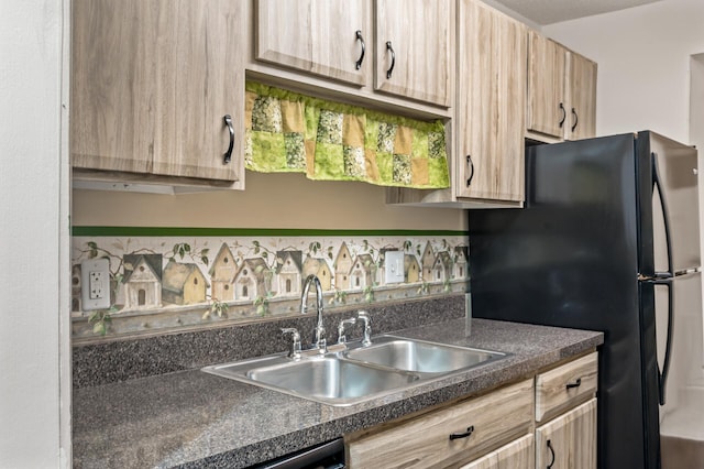 kitchen featuring stainless steel dishwasher, light brown cabinets, black fridge, and sink