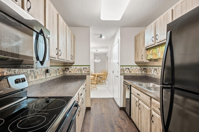 kitchen featuring light brown cabinets, sink, hanging light fixtures, stainless steel appliances, and dark hardwood / wood-style floors