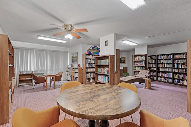 interior space featuring ceiling fan, light colored carpet, and a textured ceiling