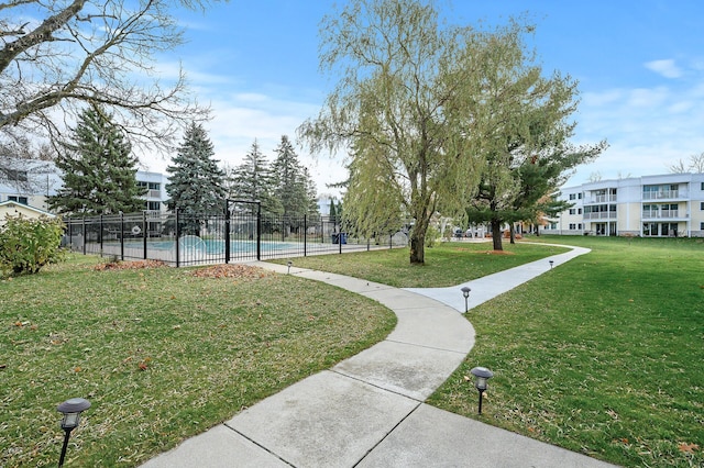 view of home's community featuring a pool and a yard