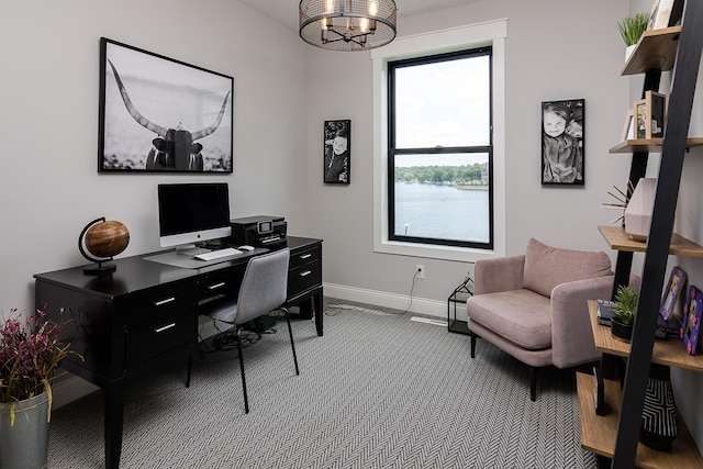 carpeted home office featuring an inviting chandelier