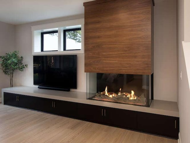 details featuring hardwood / wood-style flooring and a large fireplace