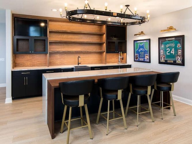 bar featuring sink and light hardwood / wood-style floors