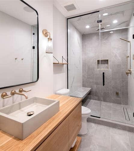 bathroom featuring tile patterned flooring, vanity, toilet, and walk in shower