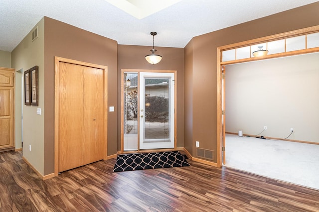 entrance foyer with a textured ceiling and dark hardwood / wood-style floors