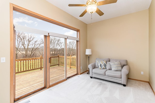 living area with ceiling fan and light carpet