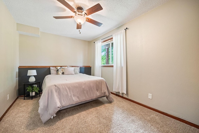 bedroom with carpet floors, ceiling fan, and a textured ceiling