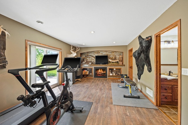 workout room with sink, hardwood / wood-style floors, and a fireplace