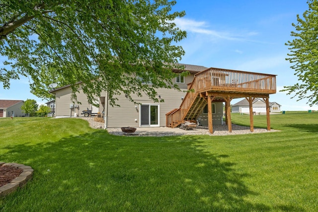 rear view of property featuring a yard, a wooden deck, an outdoor fire pit, and a patio area