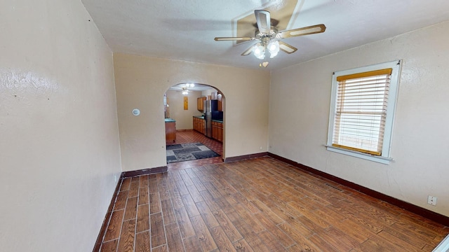 empty room featuring dark hardwood / wood-style flooring and ceiling fan