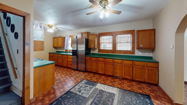 kitchen with dark parquet floors, stainless steel fridge, sink, and ceiling fan