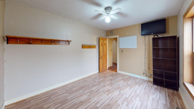 interior space featuring ceiling fan, light hardwood / wood-style floors, and a textured ceiling