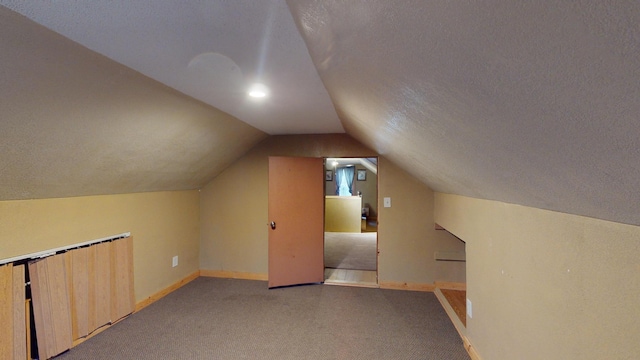 bonus room featuring light carpet, a textured ceiling, and vaulted ceiling