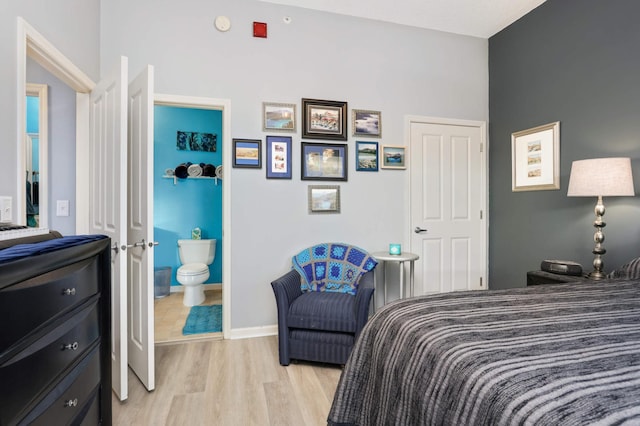 bedroom featuring ensuite bath and light wood-type flooring