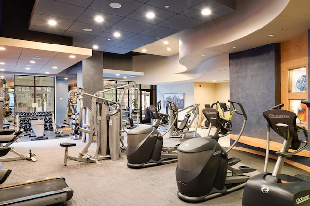 workout area with a towering ceiling and carpet floors