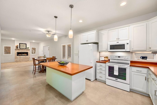 kitchen with white appliances, ceiling fan, pendant lighting, white cabinetry, and butcher block counters