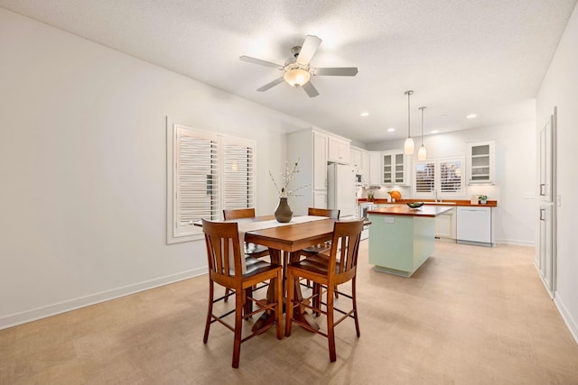 dining space featuring ceiling fan and a textured ceiling