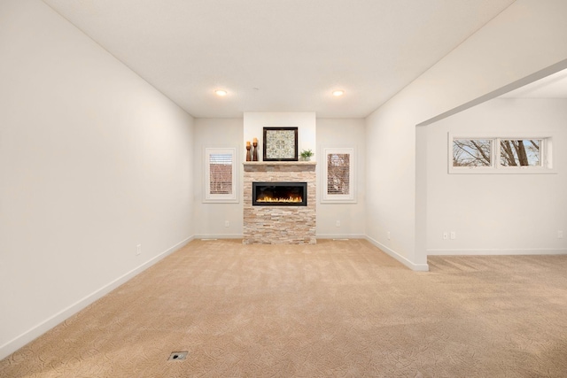 unfurnished living room featuring a fireplace and light colored carpet