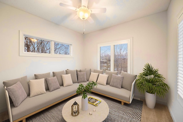 carpeted living room with ceiling fan