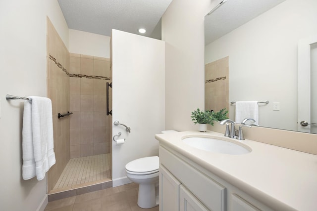 bathroom featuring a textured ceiling, vanity, tiled shower, tile patterned flooring, and toilet