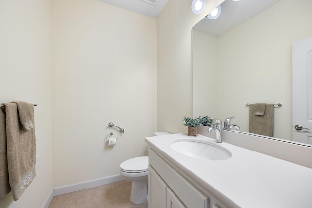 bathroom with toilet, baseboards, and vanity