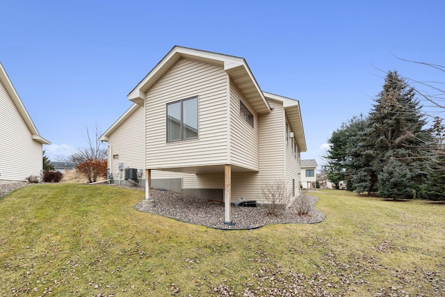 view of home's exterior with a lawn and central AC