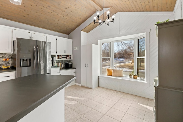 kitchen with tasteful backsplash, white cabinetry, lofted ceiling with beams, and stainless steel fridge with ice dispenser