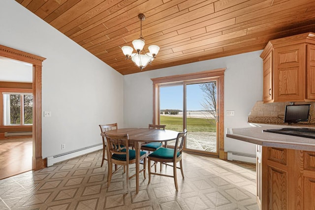 dining room with plenty of natural light, baseboard heating, and lofted ceiling