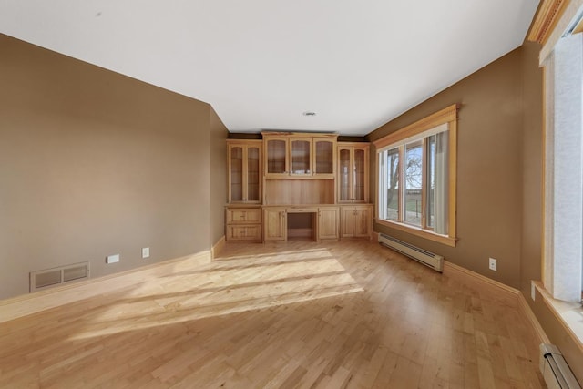 unfurnished living room with built in desk, light hardwood / wood-style floors, and baseboard heating